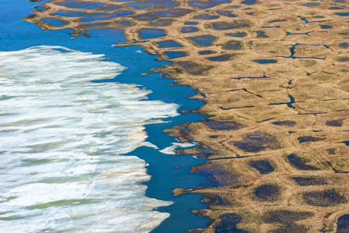 Winter ice yields to summer sunshine on an unnamed lake - he polygonal pattern on the tundra forms in areas underlain by permafrost