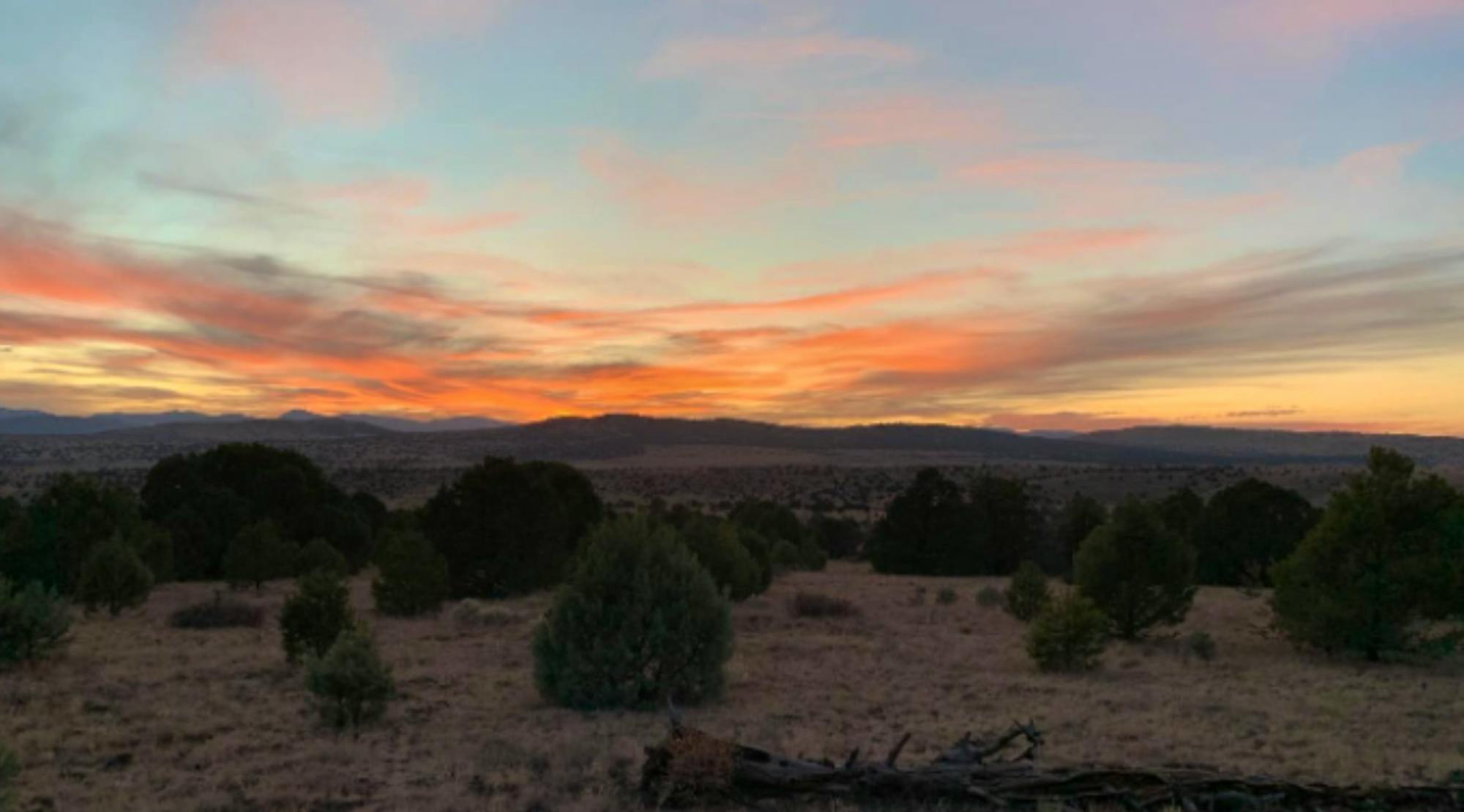 Orange sunset over mountains and bush plains 