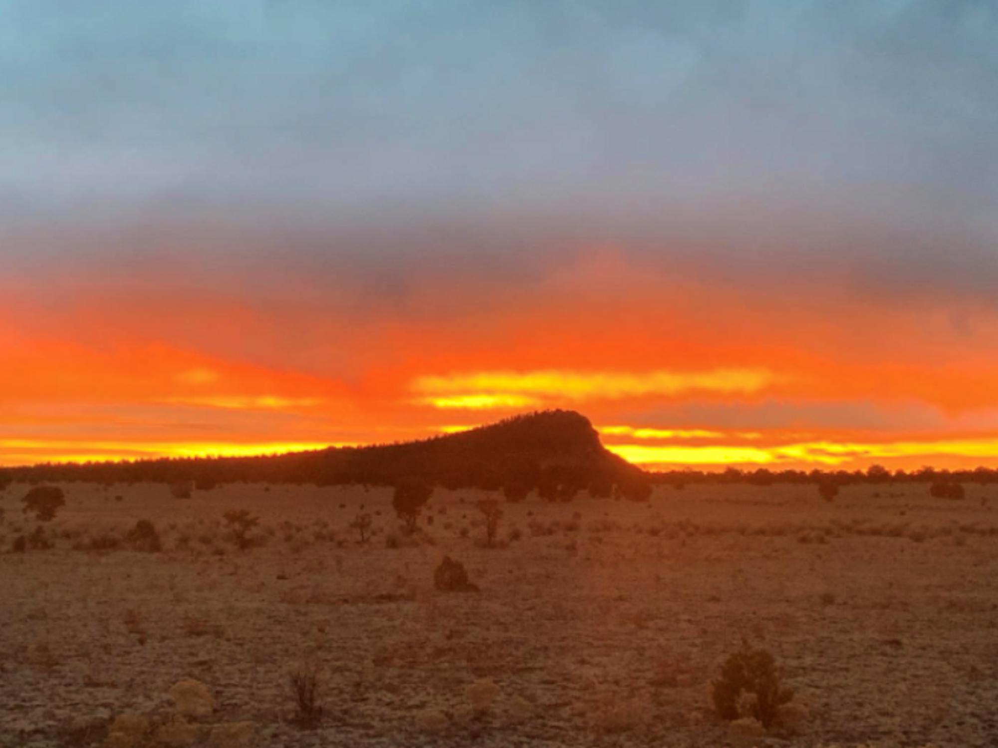 Orange Sunset over small mountain in Whiskey Creek Pack territory 