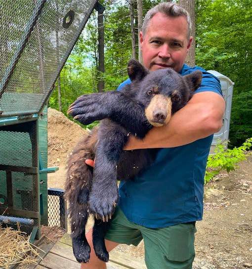 Jeff Corwin holding a black bear cub