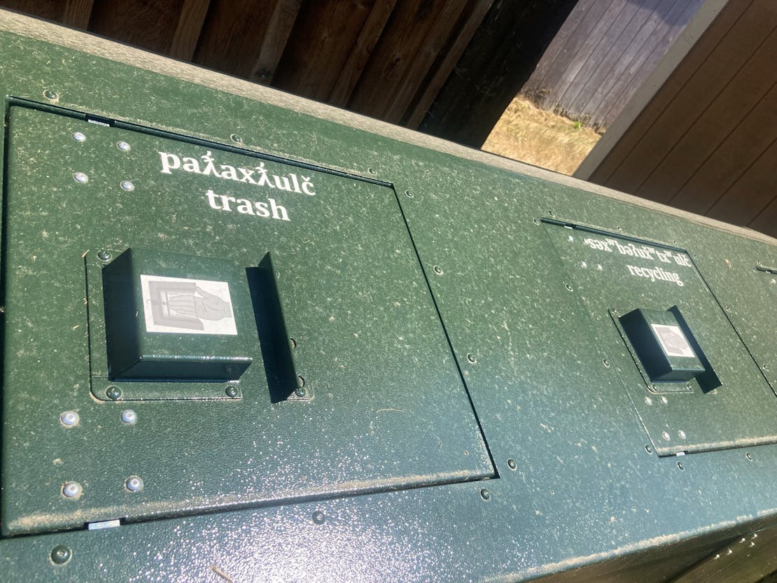 Trash and Recycling, in English and Lushootseed, on bear-resistant waste receptacles.