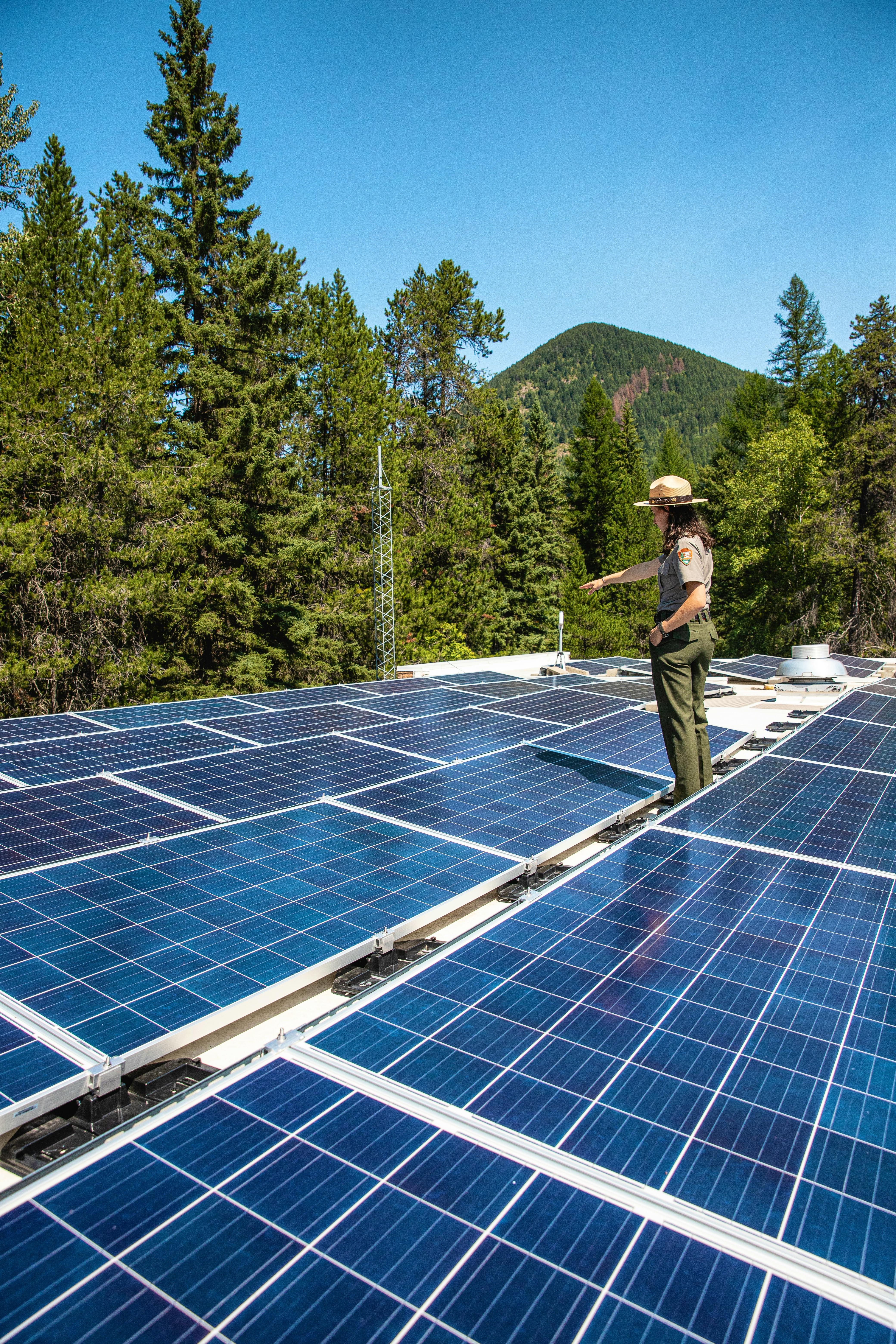 Park ranger painting at solar panels
