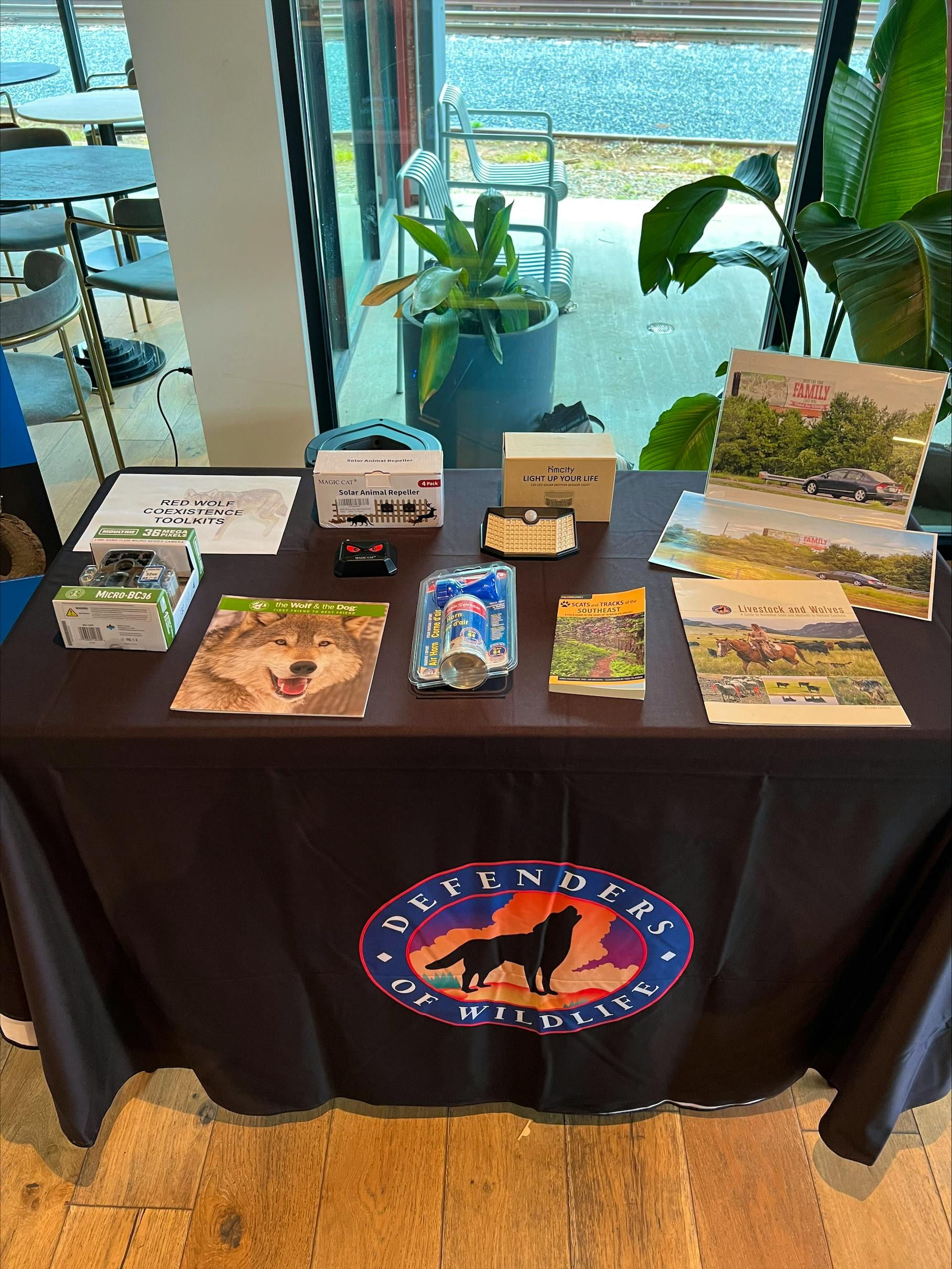 Several items are neatly laid on a table. The items are all tools and guides to help people minimize conflict with red wolves non-lethally. 