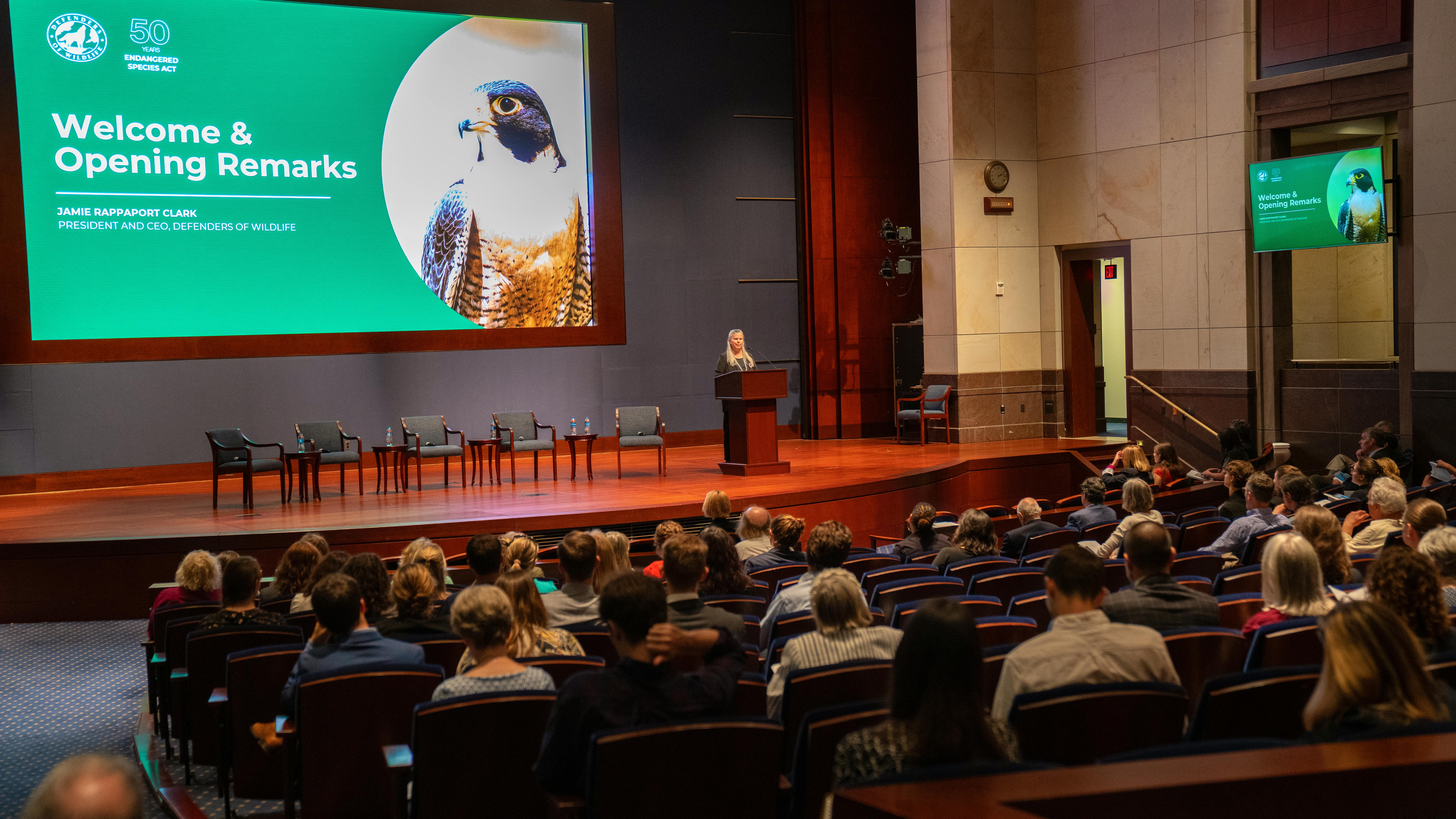 2023.09.12 - DC - ESA Symposium - Jamie Rappaport Clark delivering opening remarks from audience back left - Defenders of Wildlife