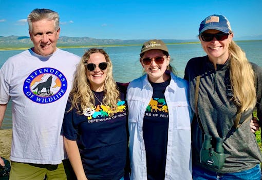 Four members of Defenders' California team (Andy Johnson, Sophia Markowaska, Ashley Overhouse and Pamela Flick) stand in front of water during their Carrizo Plain staff gathering in April 2023.