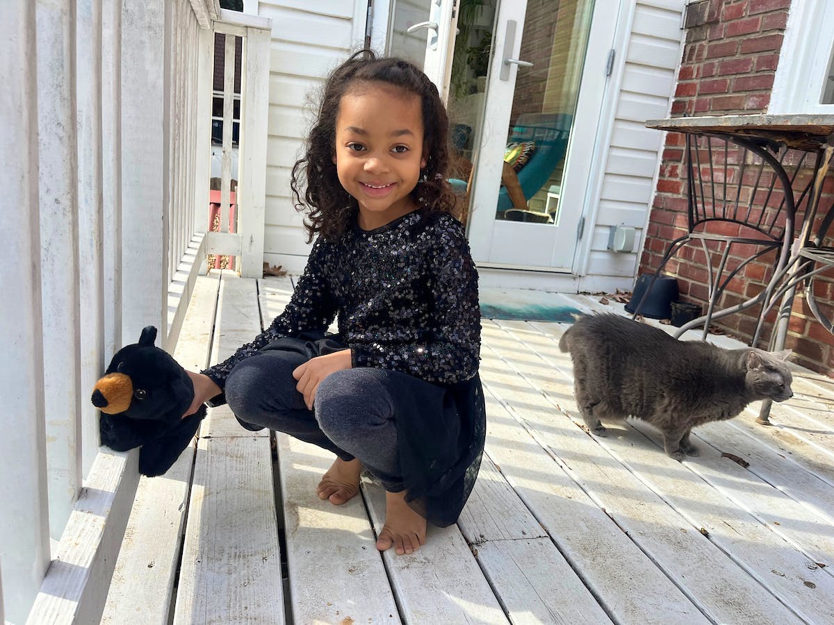 girl smiling with bear stuffie 
