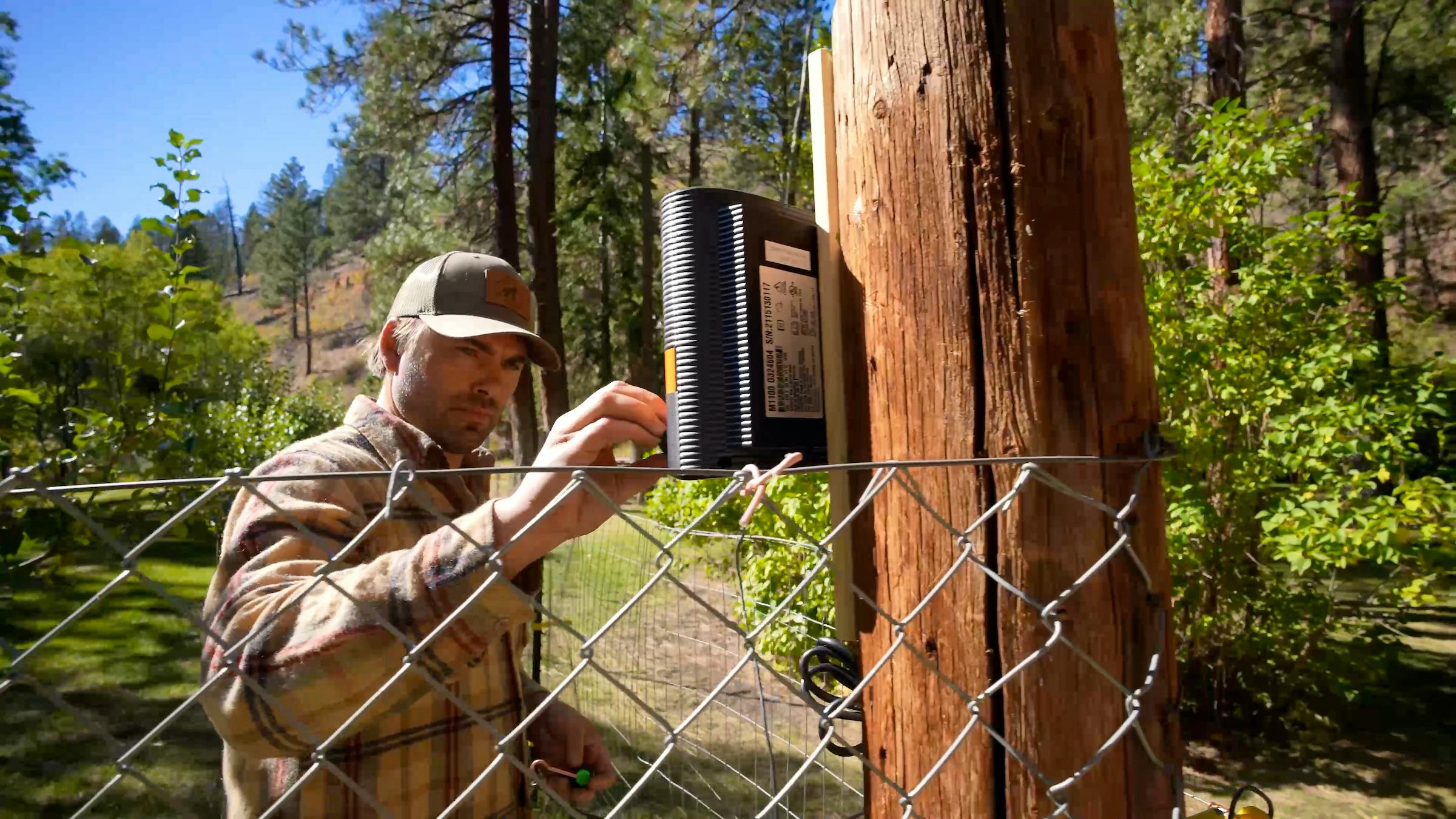 man adjusting box for electric fence, coexistence