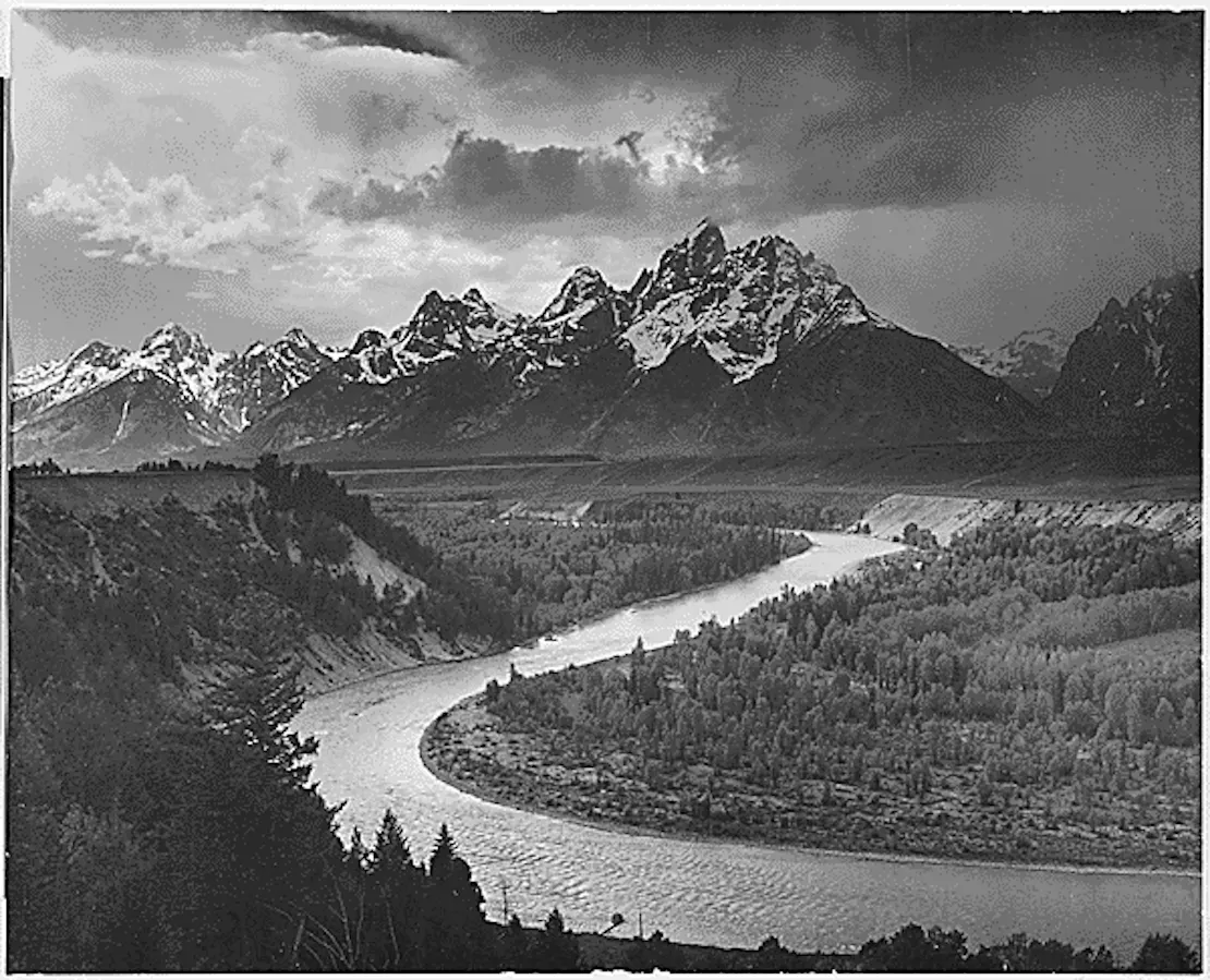 Black and white image of the Grand Tetons and Snake River running up toward them.